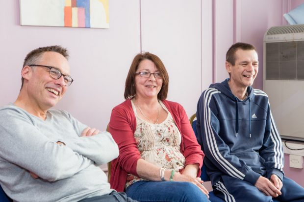 People laughing happily in a recovery group.