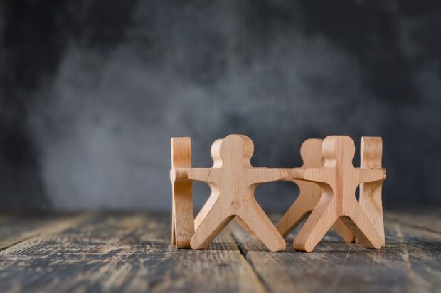 wooden figures holding hands in a circle