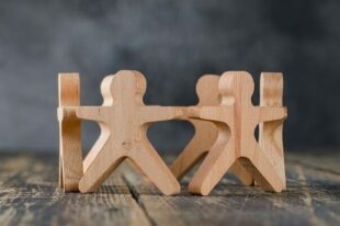 wooden figures holding hands in a circle