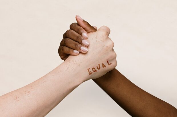 White and black hands clasped in solidarity