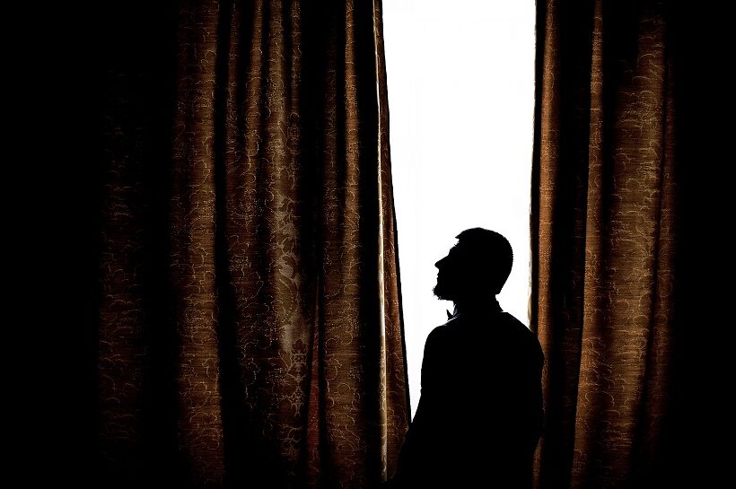 silhouette-man-standing-before-bright-window.