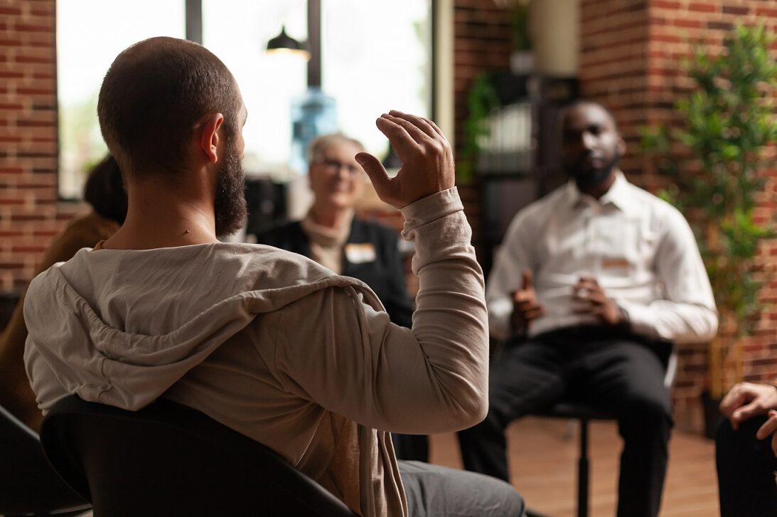 Man raising hand in mental health support group