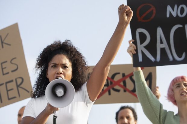 Black woman with megaphone protesting against racism.